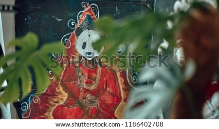 Panda is drawn in an art style. A Buddhist monk in the form of a panda holds a zen.
In the leaves of the monstera.