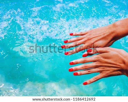 Female hands against the blue sea. Background sea