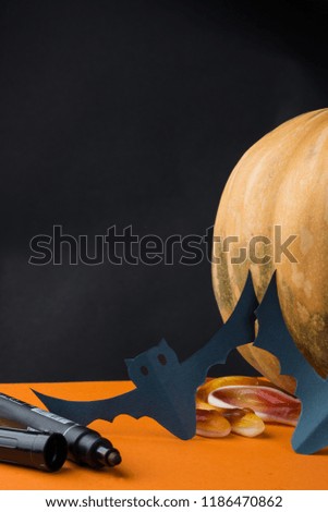 Halloween holiday background with paper bats, pumpkin and candies