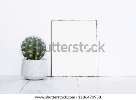 White empty blank metal text board with space for own quote or photo picture with green cactus plant on wooden floor grey wood