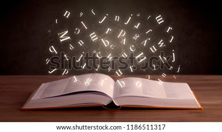 Glowing white alphabet letters coming out of an open book