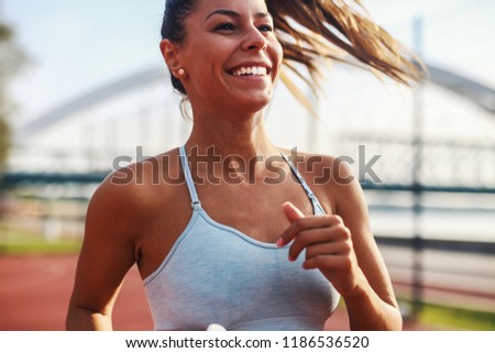 Picture of young attractive fitness girl running outdoor