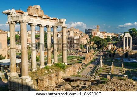 Temple of Saturn on Roman Forum, Rome, Italy. Old Forum is famous tourist attraction in Roma city. Nice panorama of Roman Forum (Foro Romano) in summer. Scenic view of Ancient ruins, World landmark.