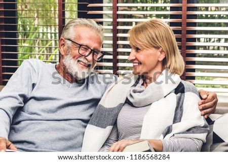 Senior couple relaxing and talking together sitting on sofa in living room at home.Retirement couple concept