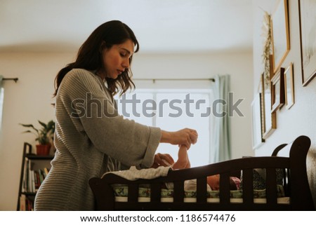 Mother changing a diaper on a newborn baby