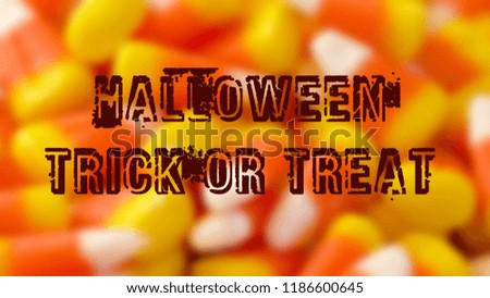 Macro closeup of Halloween traditional Candy Corn treats, blurred background with greetin text.