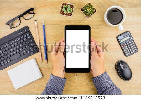 Businessman working with tablet or smartphone on office desk .Top view, business and technology concept.