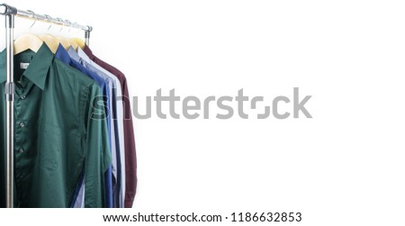 Close up green shirts or business clothes on wooden hangers, People concept, Set of mans fashion and accessories. Casual or formal tshirt. Upper section row of different coloured suit. Red, Blue, Gray