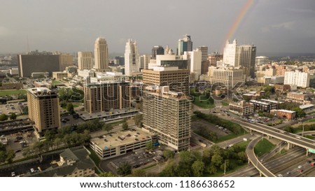 A storm just passed overhead as the sun peeks out lighting the city producing a rainbow.