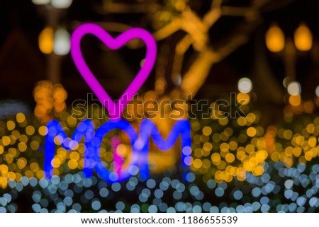 MOM word with Heart shape, LED light design style for love symbol, yellow and orange icon with bokeh bacdrop, copy space, de focus