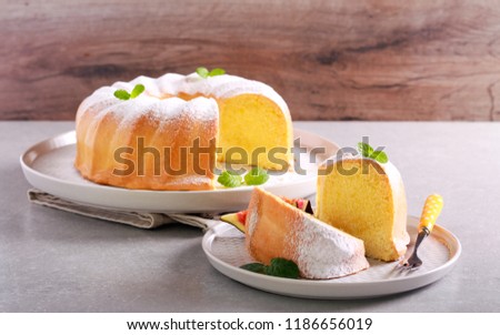 Lemon sponge ring cake with icing sugar on plate Royalty-Free Stock Photo #1186656019