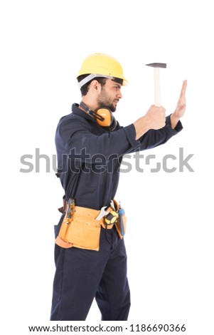 A repairman holding a hummer hitting the wall hard with it, isolated on a white background.