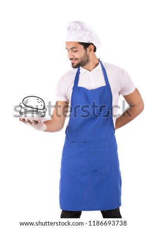 A standing young chef holding a dish, a fake bread drawing on it, his hand back, isolated on a white background.