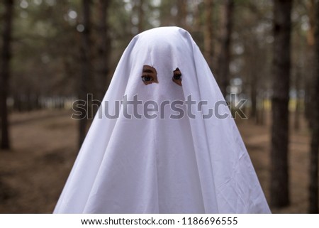 Woman in halloween ghost costume in the forest.