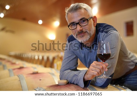 Winemaker tasting red wine in cellar Royalty-Free Stock Photo #1186697065