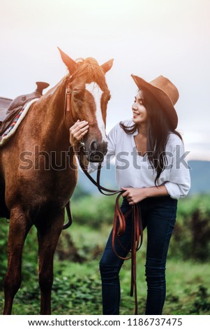 Asian young woman  take care of her blows horse at sunset.