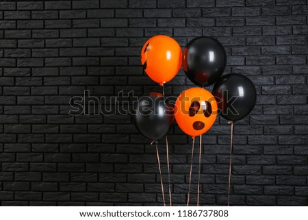 Color balloons for Halloween party on dark brick wall background