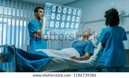 Futuristic Medical Ward with Sick Patient Lying in Bed. Doctor using Gestures and Augmented Reality Interface, Looks at Brain Scans and Medical History of the Patient. Nurse Does Checkup.