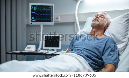In the Hospital Senior Patient Rests, Lying on the Bed. Recovering Man Sleeping in the Modern Hospital Ward. Royalty-Free Stock Photo #1186739635
