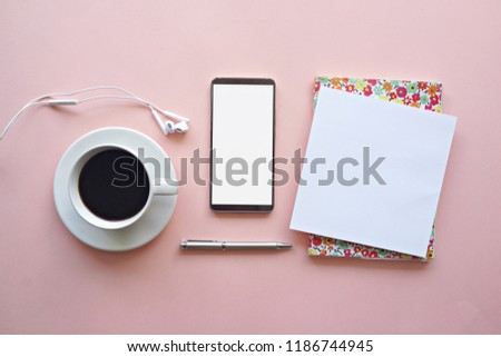 Notebook with blank pages, smartphone earphone and coffee cup on pink background. Business and education concept. Top view                 
