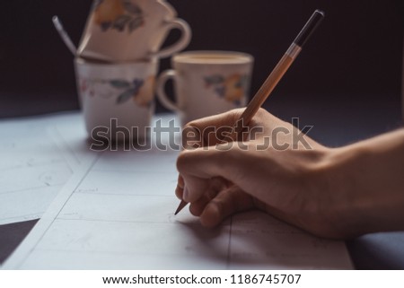 hand drawing storyboard conceptual ideas with coffee cups in the background, hard work sketching art