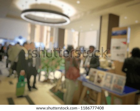 blurred image of people walking on a trade fair exhibition or expo where business people show innovation activity and present product in a big hall.
