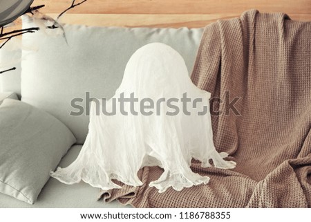 Creative ghost prepared for Halloween celebration on sofa