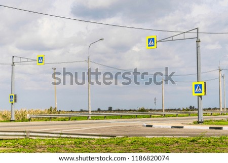 Highway in the steppe. Lamp posts, electrical wires. Sunny day. Road sign