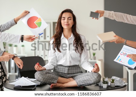 Businesswoman with a lot of work to do meditating in office Royalty-Free Stock Photo #1186836607