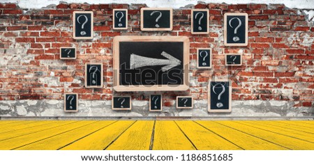 Question marks - white chalk drawing on small blackboard hanging old brick wall