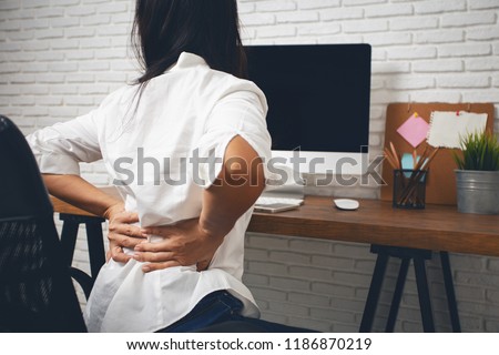 Business woman suffering from back pain in office home Royalty-Free Stock Photo #1186870219