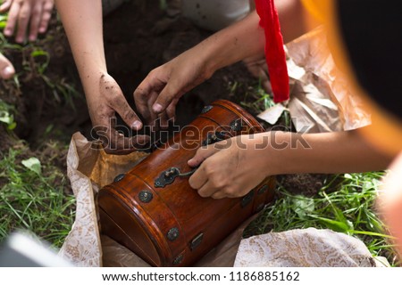 Children's Hands Dig Up the Earth in Treasure Hunt