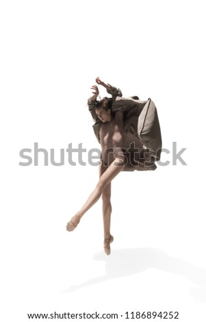 Beautiful slim young female modern jazz contemporary style ballet dancer in silhouette wearing beige long cloak isolated on a white studio background