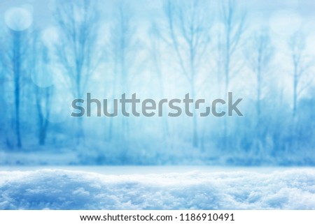 blurred icy winter landscape with snow cover in foreground, blue empty winter landscape background concept