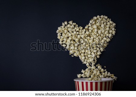 Creative layout made of popcorn in heart shape on black background. Movie lover composition. Minimal style. Flat lay. Copy space