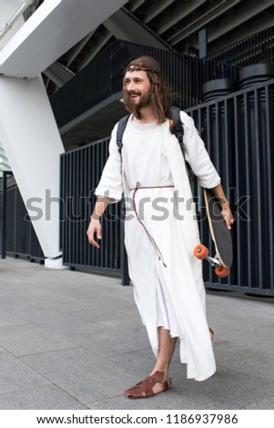 smiling Jesus in robe, crown of thorns and bag holding skateboard on street