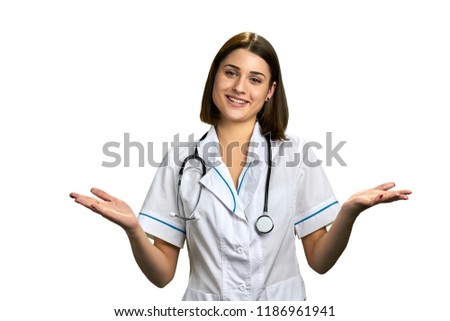 Cheerful woman doctor with outstretched hands. Young smiling female doctor gesturing with arms up, isolated on white background.