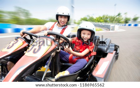 father and daughter driving go kart on the track Royalty-Free Stock Photo #1186965562