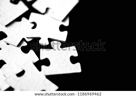 Children's puzzles scattered on a table close up. Black and white