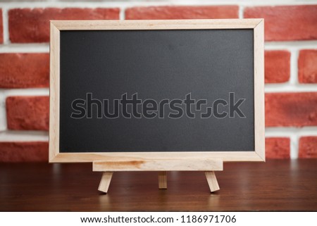 Mini Blank blackboard on wooden table at red brick wall with Copy space . chalkboard