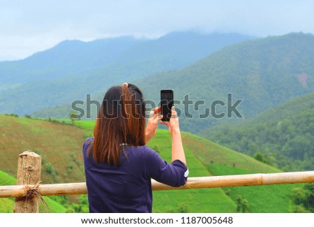 Woman taking a photo natural scenery with mobile phone