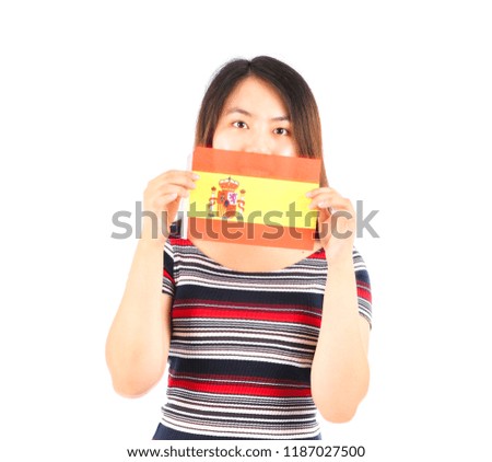 Young asian woman hiding behind a spanish flag against a white background