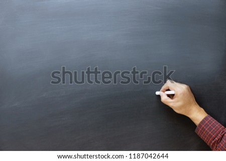 young business man Plaid shirt color red hand to draw and writing something on blackboard with chalk. or Education back to school concept / chalkboard. Leave blank empty space to write text.