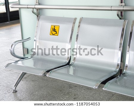 Stainless steel chairs in the train station with disabled signage to facilitate the use of train services for the disabled.