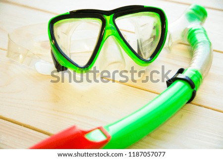 Preparing for vacation, travel or journey. Travel planning. Green swimming mask on white wooden background.