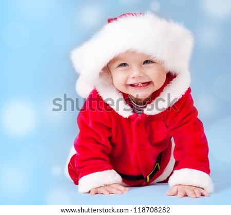 Sweet baby wearing Santa costume, over blue background with copyspace