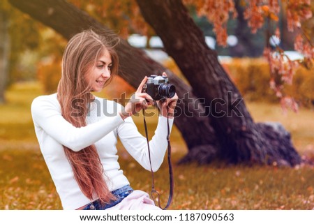Pretty romantic young woman with a vintage camera, in the fall, toning