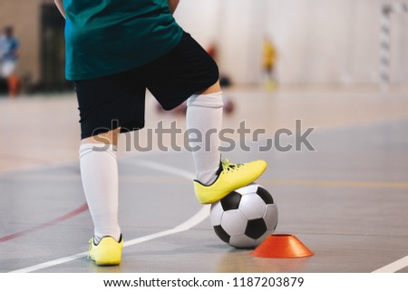 Indoor soccer player training with balls. Indoor soccer sports hall. Football futsal player, ball, futsal floor. Sports background. Futsal league. Indoor football players with classic soccer ball. Royalty-Free Stock Photo #1187203879