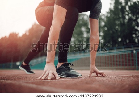 Close-up foot athlete runner at start of football field, artificial lawn.