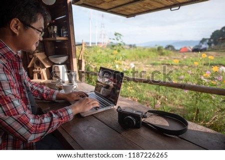 Asian freelance photographer working online during travel time 